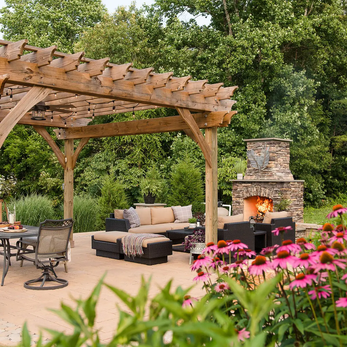paver patio with pergola, outdoor fireplace, and native landscaping