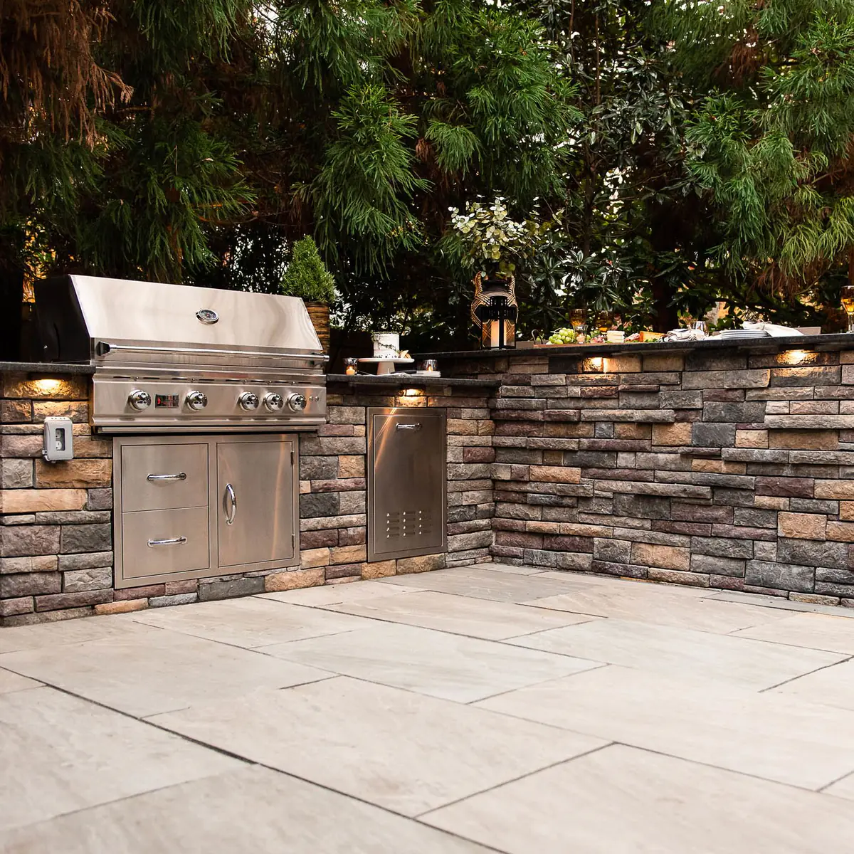 Stainless Steal gas grill installed into a stacked veneer outdoor island