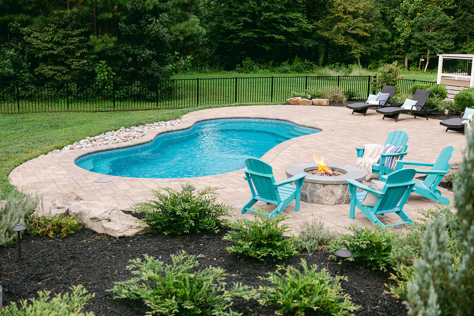 custom outdoor poolscape with landscaping and firepit