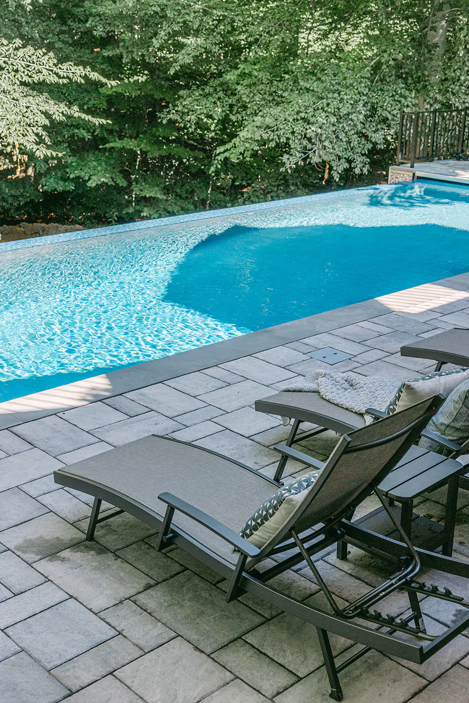 pool chairs by blue pool with infinity edge