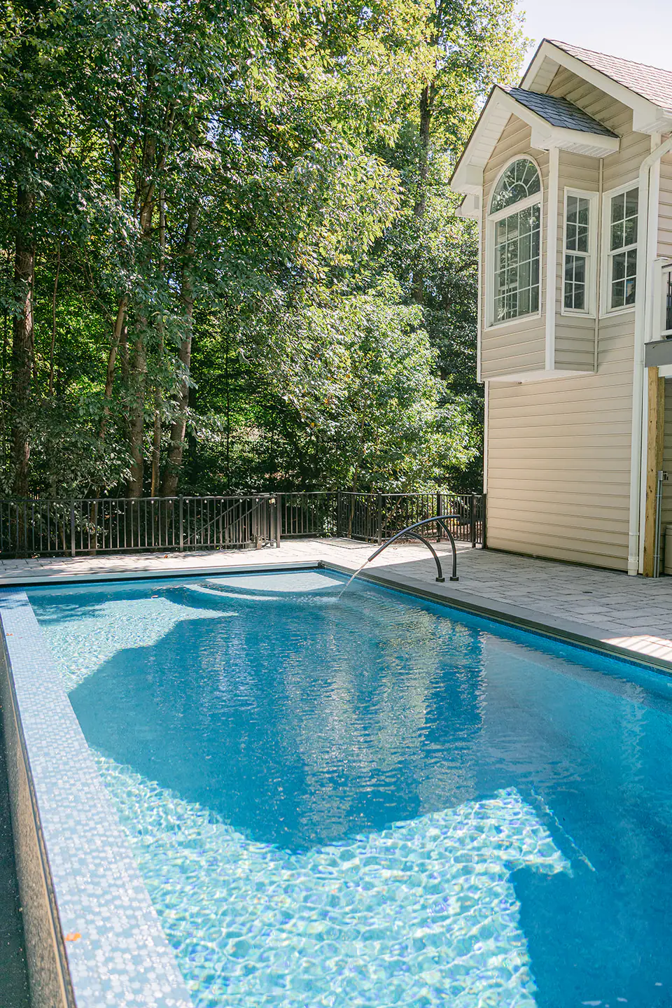 custom built gunite pool with house and trees in background